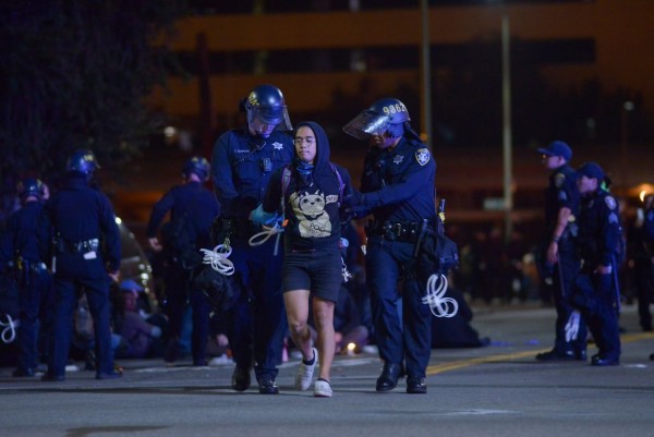 Oakland’da 24 Mayıs Cumartesi günü polis tarafından alıkonulan bir gösterici Fotoğraf: James Tensuan