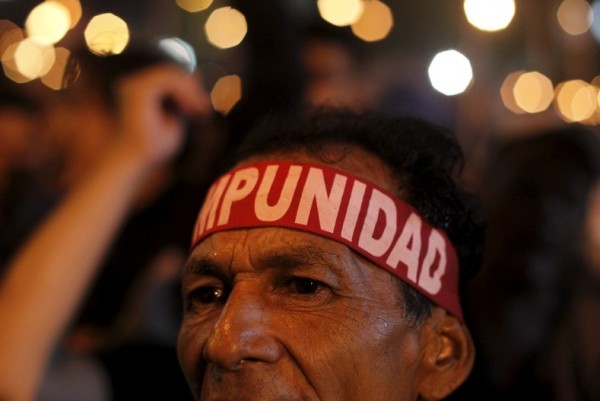 A man wearing a headband that reads "Impunity" takes part in a march to demand the resignation of Honduras' President Juan Orlando Hernandez in Tegucigalpa
