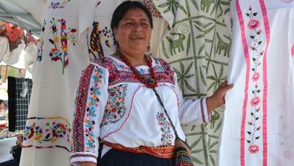 Costanca Garcia Lopez, Oaxacalı yerli bir kadın, aile içi şiddetten kurtulan diğer kadınların yaptıkları el emeği giysilerle görülüyor. | Fotoğraf: EFE