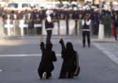 FILE- In this Wednesday, Jan. 18, 2012 file photo, Bahraini anti-government protesters kneel in the street and gesture toward riot police, in Manama, Bahrain. Bahrains security forces tortured detainees in the years after its 2011 protests despite a government promise to stop such abuses in the island nation, according to a new report released Monday. The Human Rights Watch report on Bahrain, home to the U.S. Navys 5th Fleet, corresponds with accounts of abuse provided by Amnesty International and local activists.(AP Photo/Hasan Jamali, file)